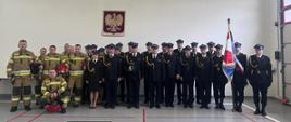 Zdjęcie przedstawia zdjęcie grupowe podczas uroczystości pożegnania funkcjonariusza