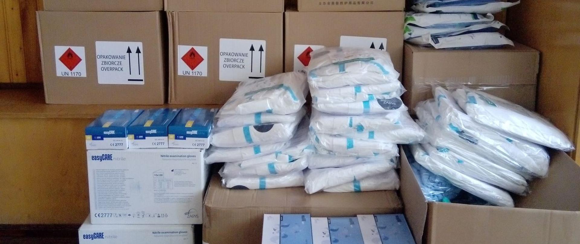 Zdjęcie środków ochrony indywidualnej -maseczki, rękawice nitrylowe, kombinezony, płyn do dezynfekcji rąk i powierzchni, przyłbice.