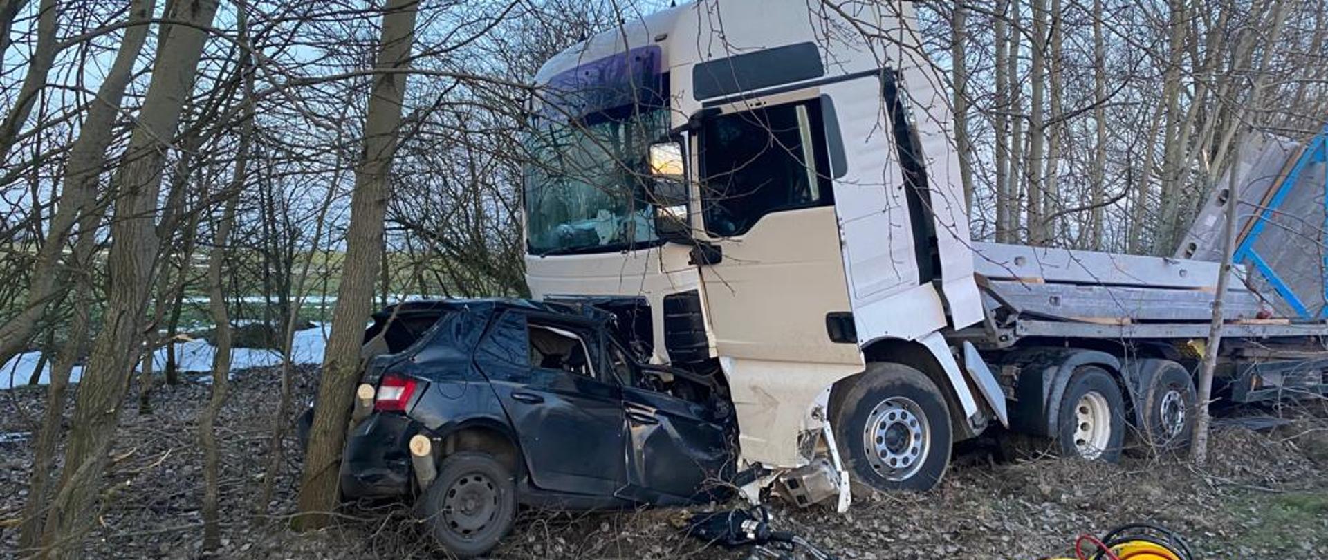 zmiażdżony samochód pod samochodem ciężarowym