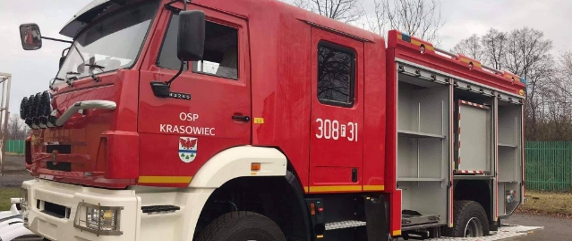 Zdjęcie przedstawia średni samochód ratowniczo-gaśniczy należący do ochotniczej straży pożarnej w Krasowcu. Samochód ma otwarte skrytki.