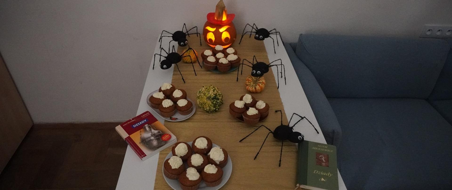 Stół udekorowany dyniami, muffinkami i pająkami na spotkanie z młodzieżą.