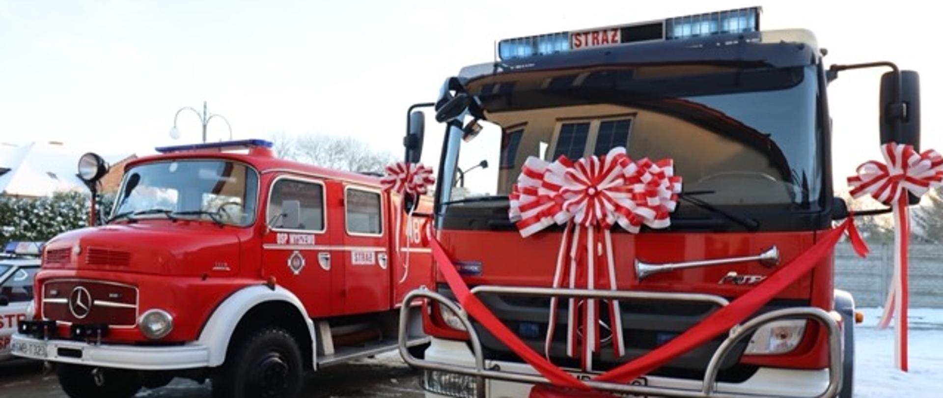 Dwa pojazdy pożarnicze jeden ozdobiony kokardami
