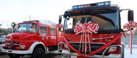 Dwa pojazdy pożarnicze jeden ozdobiony kokardami