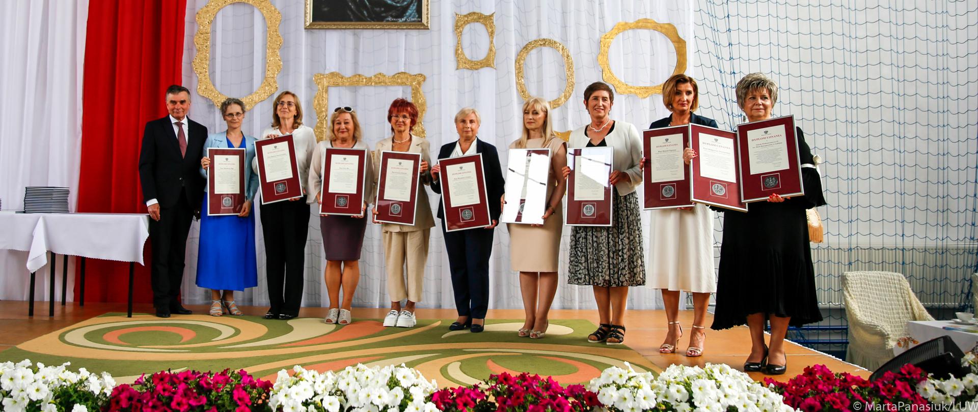 Osoby wyróżnione Dyplomami Uznania pozują do pamiątkowego zdjęcia.