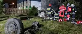 Na pierwszym planie kolo. W tle strażacy prowadzący działania ratownicze.