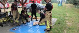 Strażacy ćwiczą udzielenia pierwszej pomocy na manekinie.