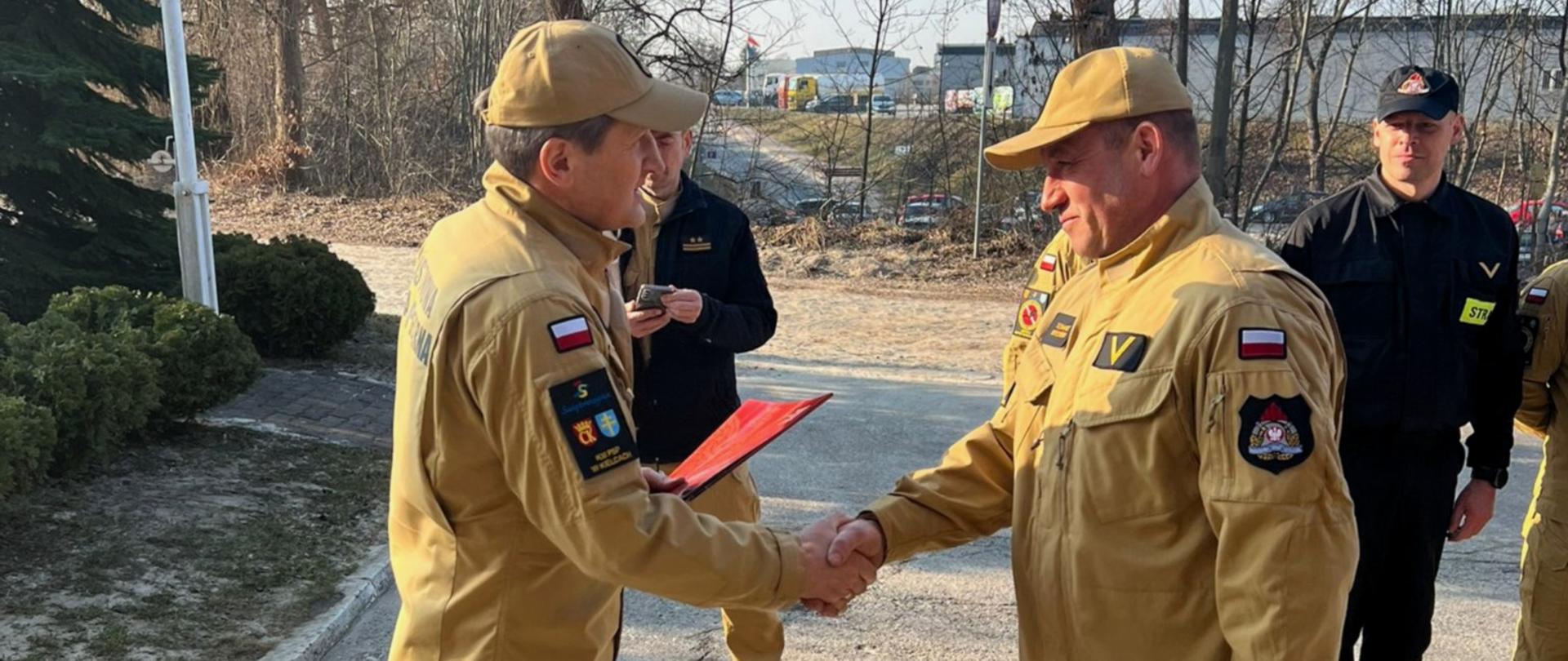 Fotografia przedstawia funkcjonariusza odbierającego nagrodę od Komendanta Miejskiego PSP w Kielcach