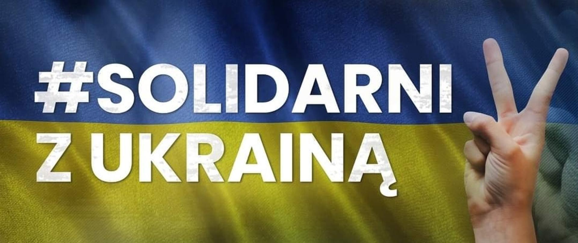 napis Solidarni z Ukrainą, na tle flagi Ukrainy