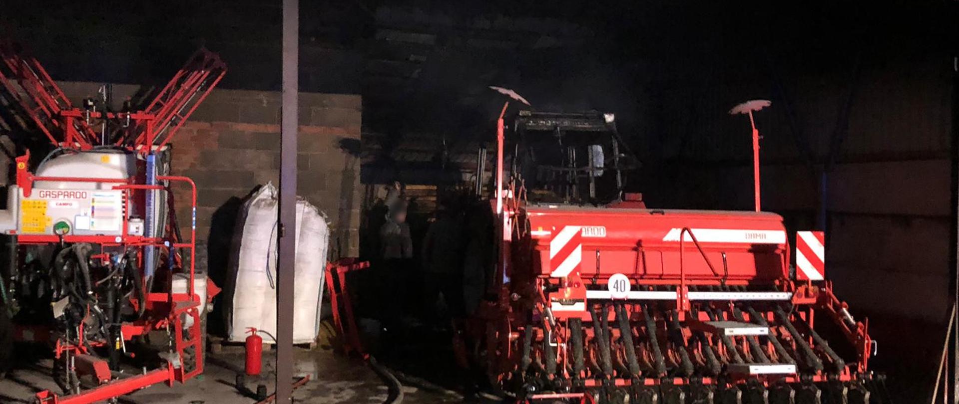 widoczne miejsce zdarzenia maszyny rolnicze i wrak ciągnika objętego pożarem.
