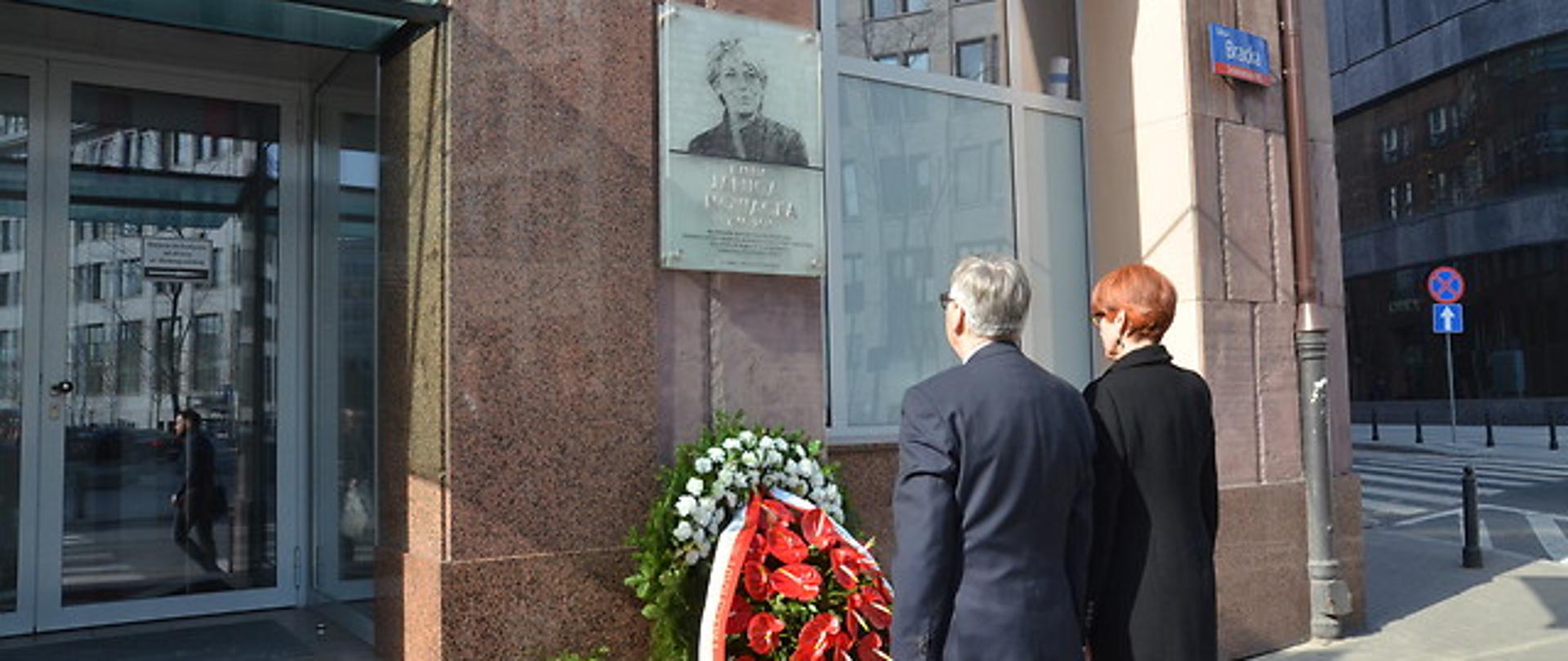 Minister Rafalska i wiceminister Szwed przed tablicą upamiętniającą minister Jarugę-Nowacką. 