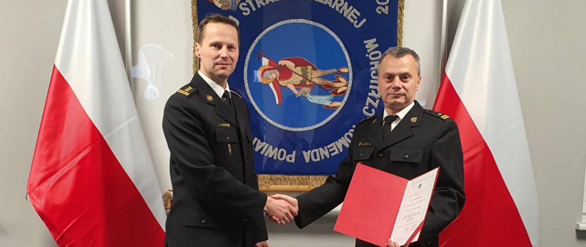 W świetlicy Komendy Powiatowej PSP w Człuchowie, na tle sztandaru, mł. bryg. Piotr Głodowski odbiera awans na stanowisko Zastępcy Dowódcy JRG z rąk Komendanta Powiatowego st. bryg. Ernesta Szczepańskiego