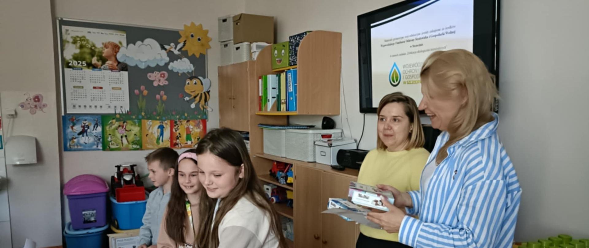 Zdjęcie przedstawia pracowników WIORiN w Choszczenie prowadzących prelekcję dla uczniów klas 0-3 Szkoły Podstawowej w Sławęcinie.