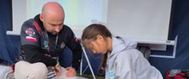 Uczestniczka stoiska Ochrony Cywilnej i Obrony Ludności podczas ćwiczeń z pierwszej pomocy.