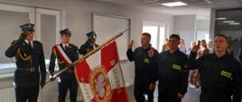 str. Filip Czapiewski, str. Michał Jankowski i str. Nikodem Szmurło (od lewej) składają ślubowanie. Po lewej stronie poczet sztandarowy, w tle rodziny nowych funkcjonariuszy.