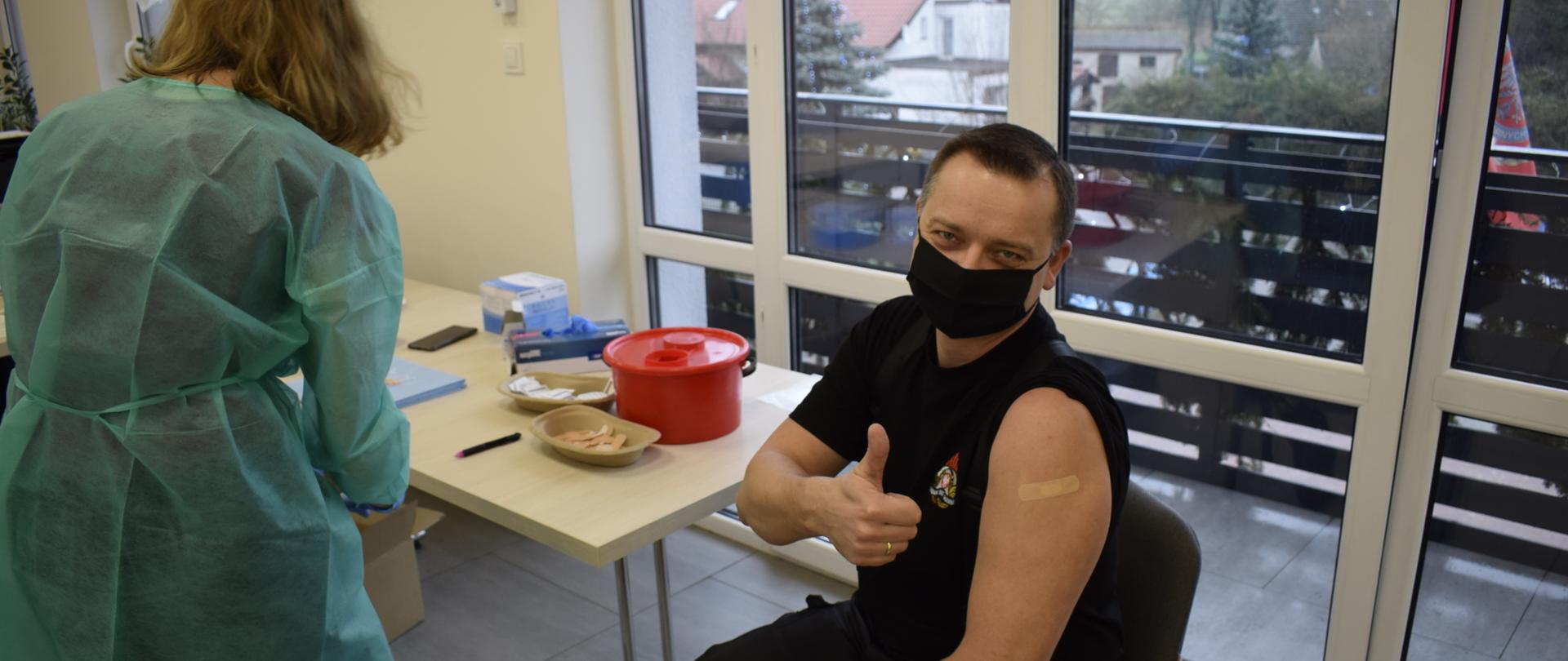 Pielęgniarka zespołu szczepiącego szczepi osobę - Zastępcę Komendanta Powiatowego PSP w Międzychodzie.