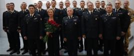 Europosłanka Jadwiga Wiśniewska na pamiątkowym zdjęciu w towarzystwie Komendanta Centralnej Szkoły PSP, Mazowieckiego Komendanta Wojewódzkiego PSP, Zastępcy Komendanta Centralnej Szkoły PSP, dwóch oficerów PSP oraz stojących z tyłu grupy kadetów CS PSP