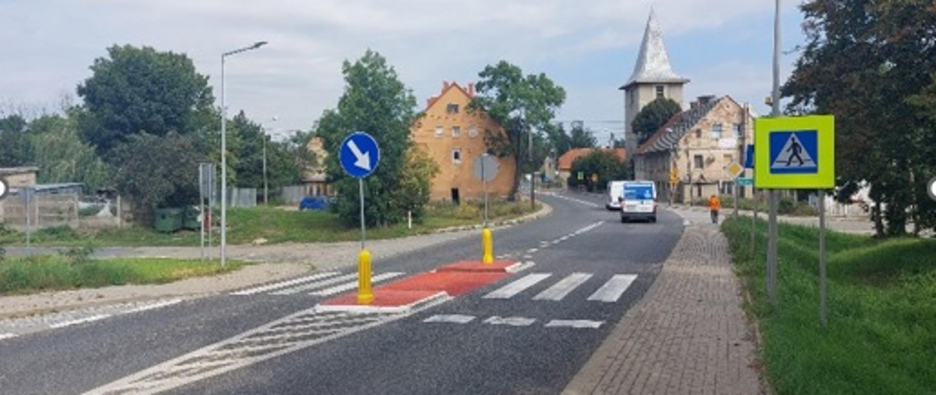 na zdjęciu widoczna droga , przejście dla pieszych, w tle domy i samochody 