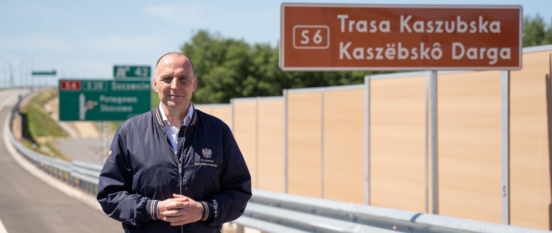 wojewoda na tle tablicy z napisem Trasa Kaszubska