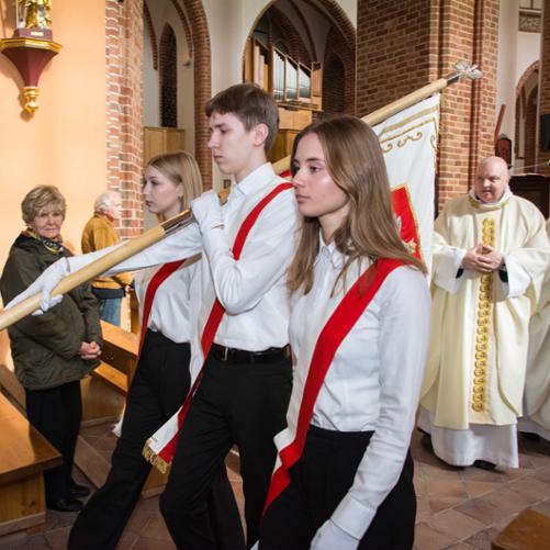 zdjęcie przedstawia poczet sztandarowy odchodzący od ołtarza nawą główną katedry