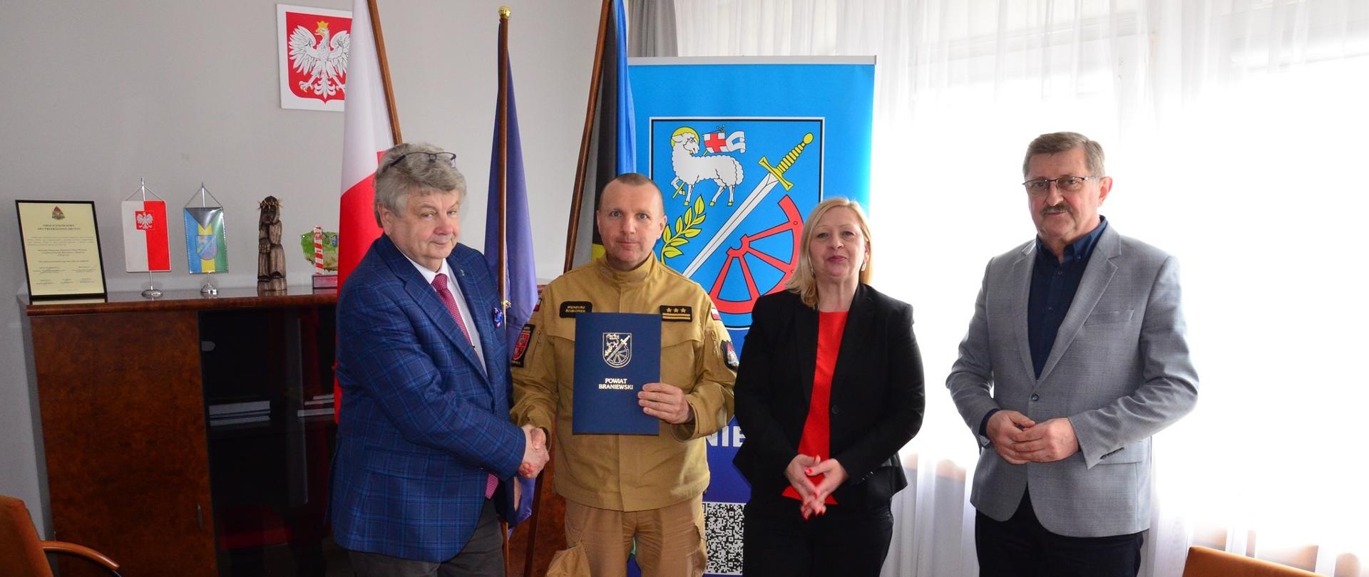 Gabinet starosty braniewskiego. Od lewej stoją starosta braniewski, komendant powiatowy PSP, skarbnik starostwa oraz wice starosta braniewski.
