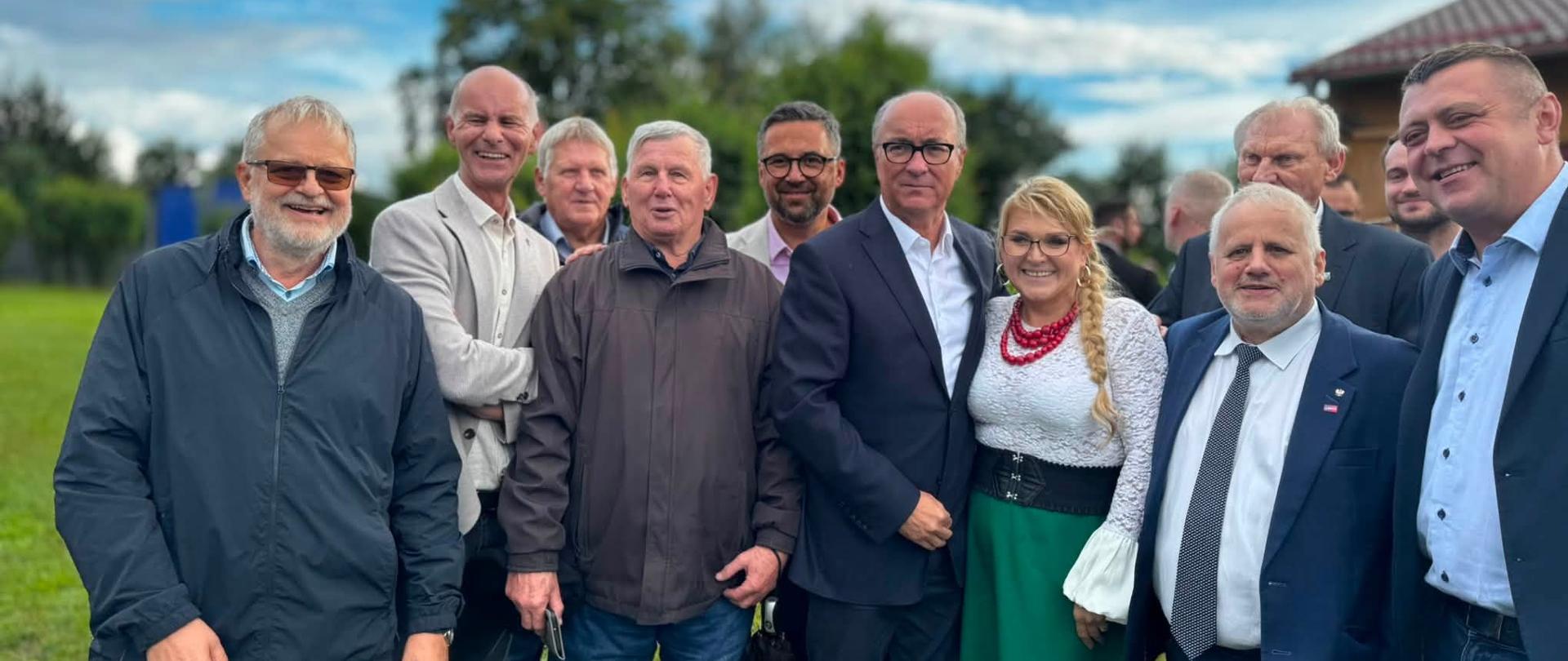 Grupa uczestników wydarzenia, wśród których znajdują się przedstawiciele władz oraz wicewojewoda Zbigniew Szczypiński w granatowej marynarce, pozuje do wspólnego zdjęcia.