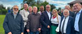 Grupa uczestników wydarzenia, wśród których znajdują się przedstawiciele władz oraz wicewojewoda Zbigniew Szczypiński w granatowej marynarce, pozuje do wspólnego zdjęcia.