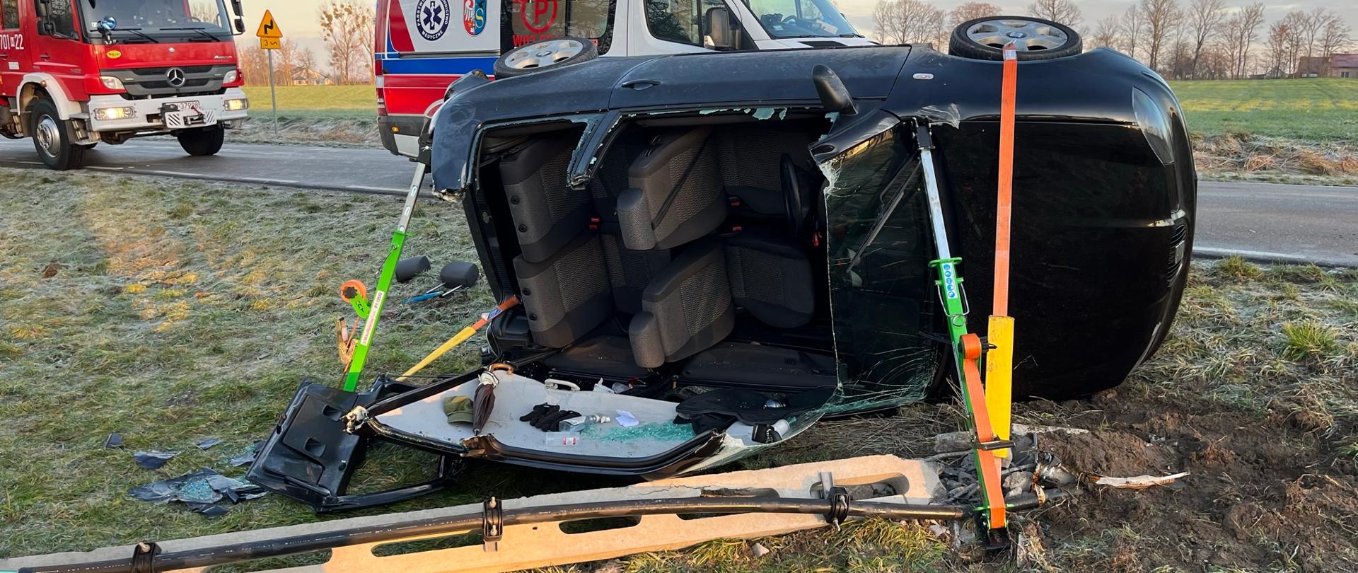 Samochód przewrócony na bok po uderzeniu w betonowy słup