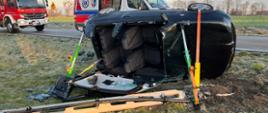 Samochód przewrócony na bok po uderzeniu w betonowy słup