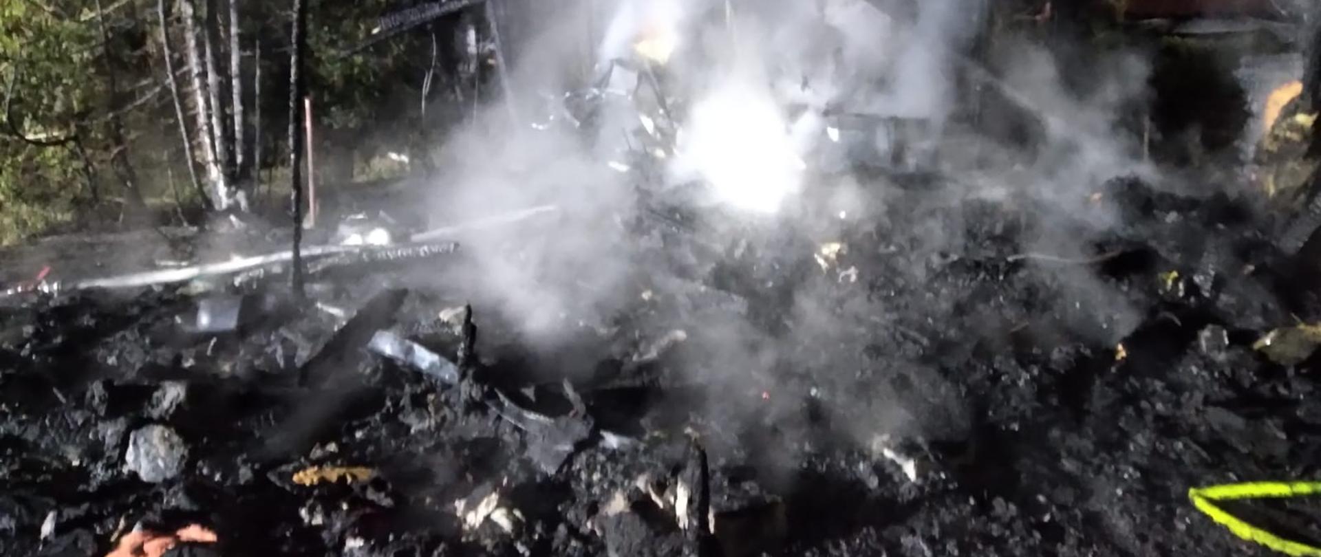 Zdjęcie przedstawia spalony domek letniskowy