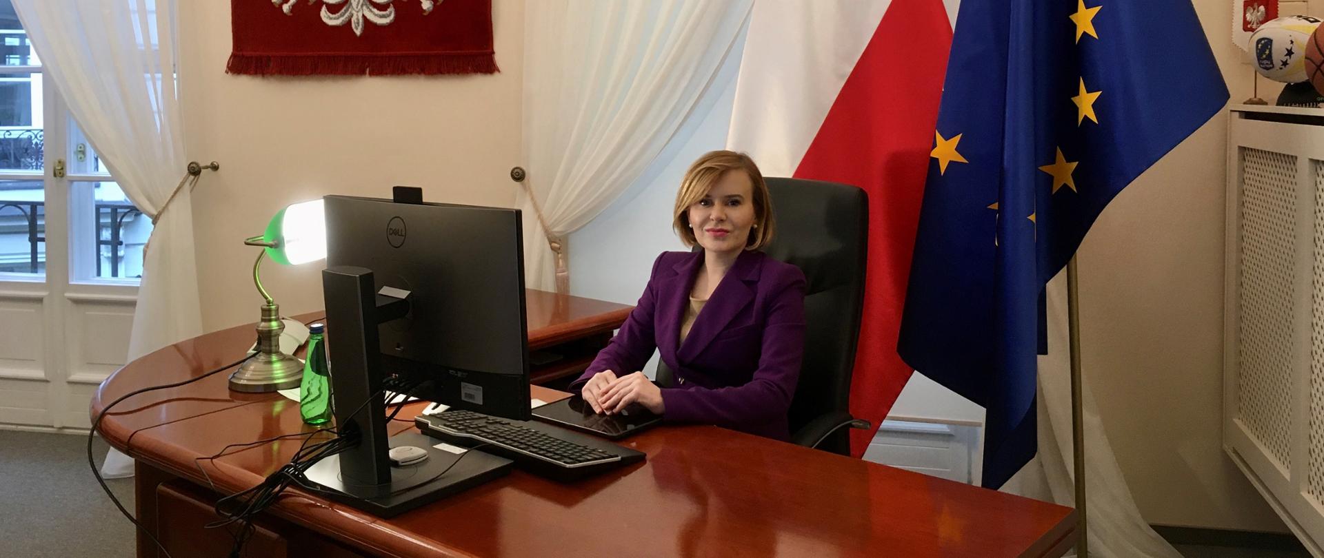 Sekretarz Stanu Anna Krupka siedząca przy biurku, przed ekranem komputera