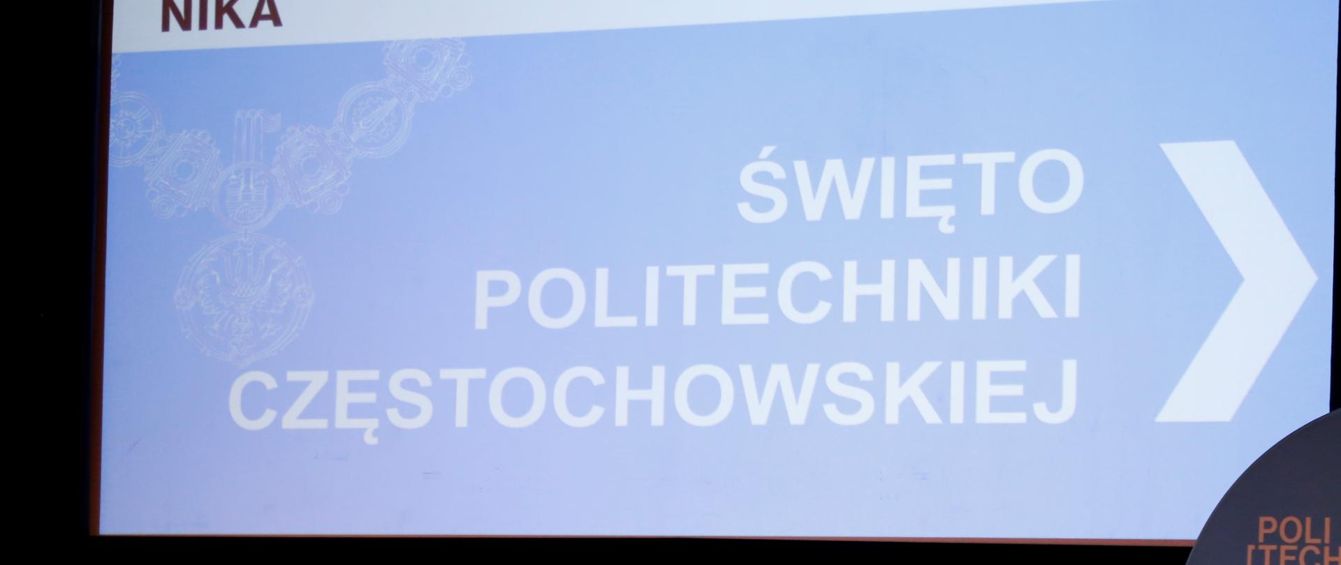 Fragment sceny, po lewej i prawej stronie ustawione krzesła u góry ekran multimedialny z wyświetlonym slajdem na którym na niebieskim tle widnieje napis "Święto Politechniki Częstochowskiej"