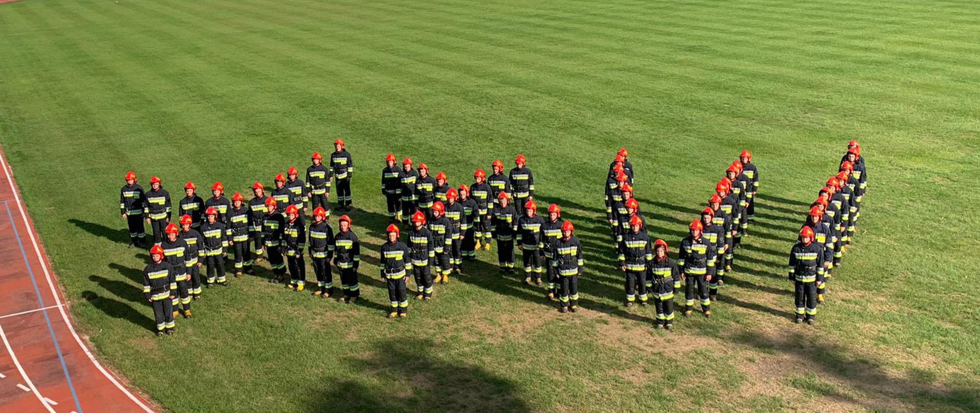 Widok z góry. Kadeci XXVI turnusu DSA w umundurowaniu bojowym utworzyli na murawie stadionu Centralnej Szkoły napis "XXVI"