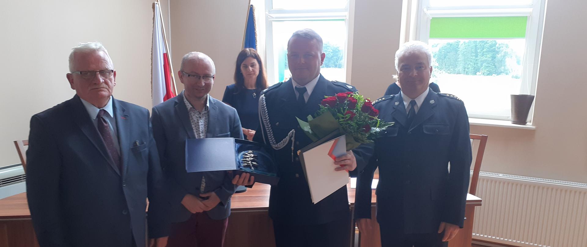 W urzędzie gminnym wręczeniem kwiatów i listu gratulacyjnego dla druha OSP. Obecny Komendant Powiatowy PSP, wójt oraz inni urzędnicy.