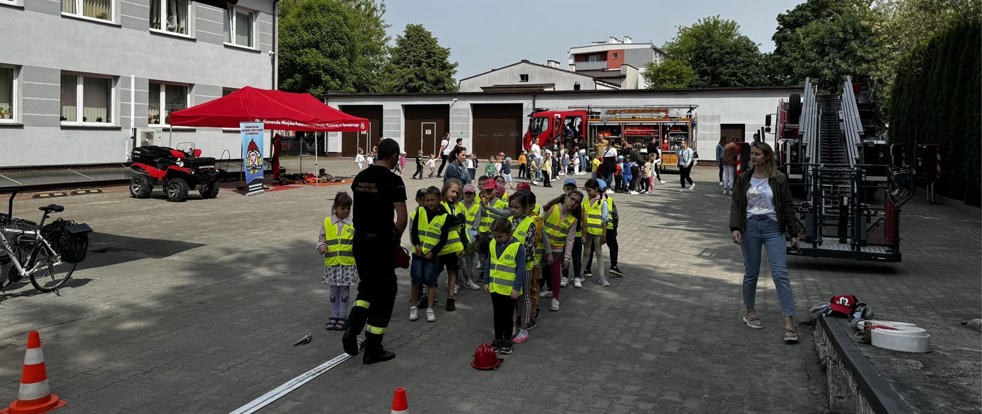 Dzieci uczestniczą w zabawie strażackiej związanej z torem przeszkód