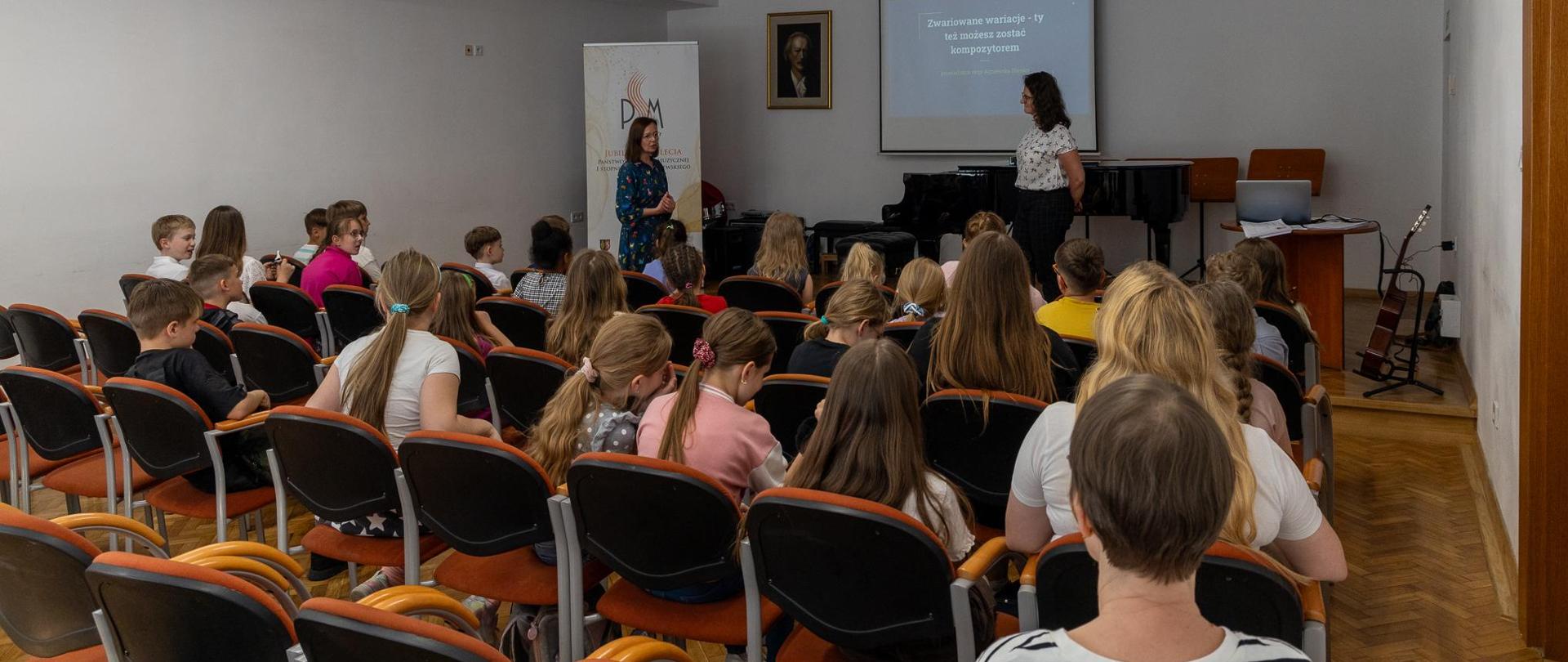 Koncert i warsztaty kompozytorskie 2024. Pani Agnieszka Niesler prowadząca warsztaty kompozytorskie. Uczniowie zgromadzeni na warsztatach w auli PSM w w Głubczycach.