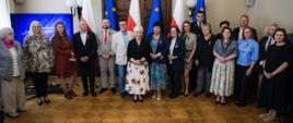 Pamiątkowa fotografia wojewody łódzkiego Doroty Ryl z wyróżnionymi mieszkańcami województwa łódzkiego 
