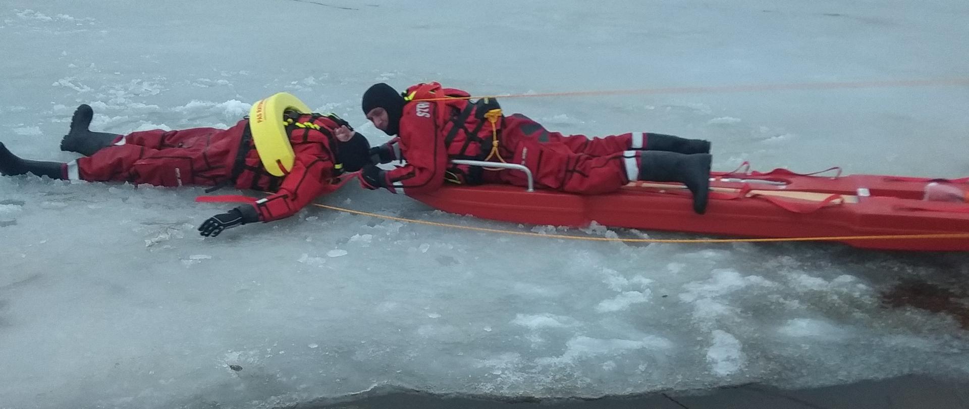 Zdjęcie przedstawia ćwiczenia strażaków JRG i OSP z ratownictwa lodowego na zalewie w Korycinie