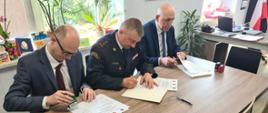 Zdjęcie przedstawia Komendanta Powiatowego PSP w Zgierzu, Starostę Zgierskiego oraz Burmistrza Miasta Strykowa podpisujących porozumienie dotyczące przekazania działki pod budowę nowej strażnicy dla Jednostki Ratowniczo - Gaśniczej Państwowej Straży Pożarnej w Strykowie.