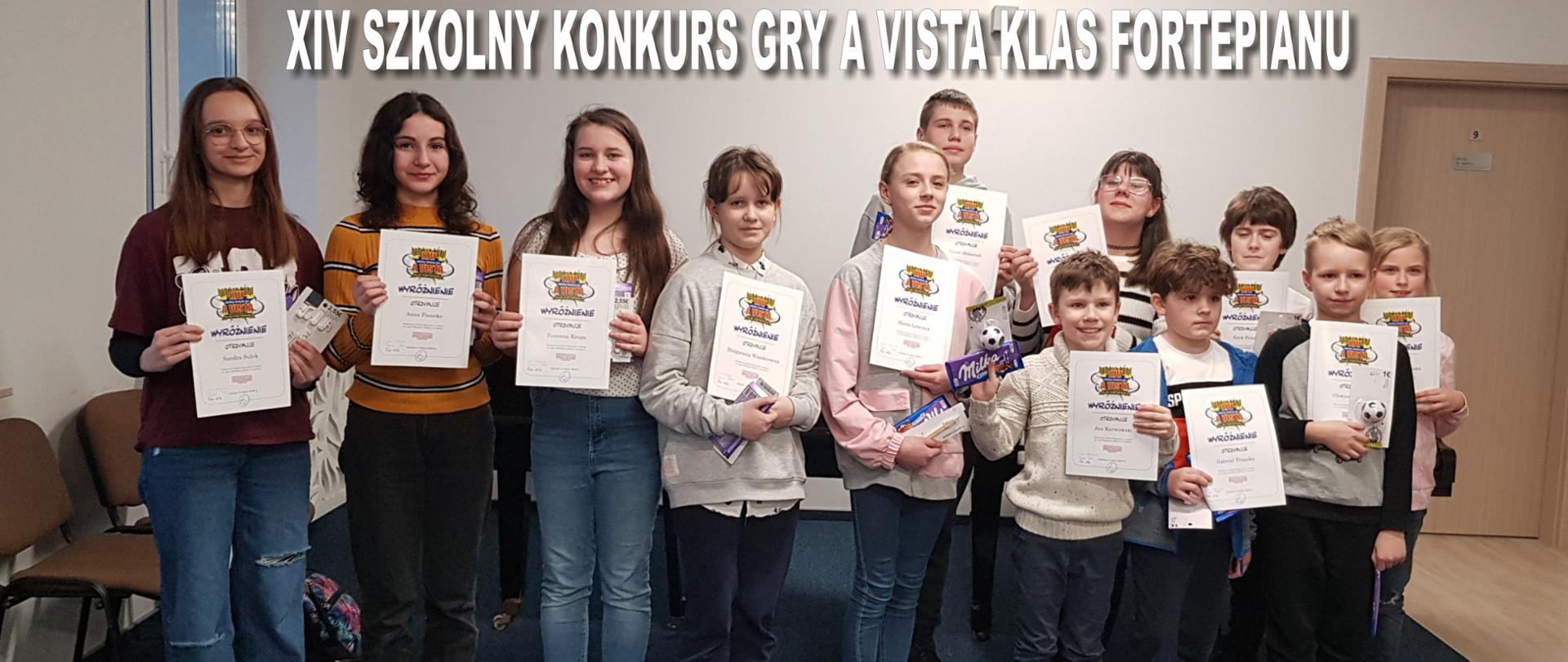 Grupa dzieci trzyma w rękach dyplomy wyróżnienia za udział w szkolnym konkursie gry a vista klas fortepianu.