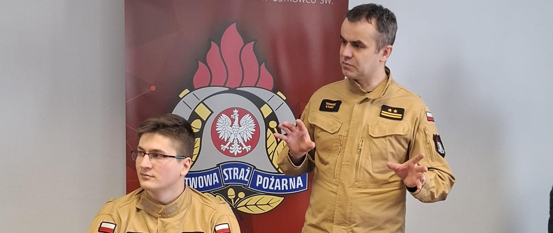 Na zdjęciu widoczny Zastępca Komendanta Powiatowego Państwowej Straży Pożarnej w Ostrowcu Św. oraz funkcjonariusz KP PSP w Ostrowcu Św. w trakcie prowadzenia prelekcji na temat czujek dymu i tlenku węgla.