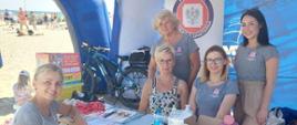 Na zdjęciu widać osoby w punkcie informacyjnym PSSE w Gdyni zlokalizowanym na plaży w Gdyni