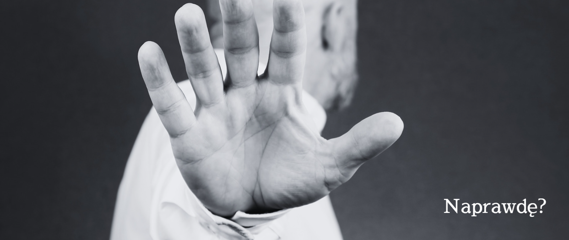 Zbliżenie ręki mężczyzny w geście powstrzymywania. Napis: Naprawdę?