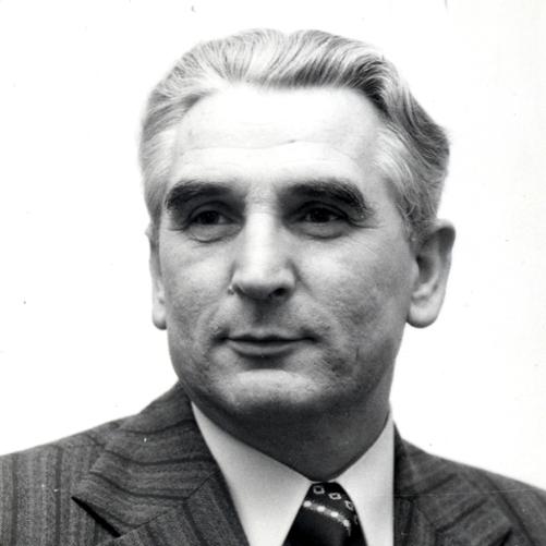 Józef Czyrek czarno - biały portret mężczyzny. siwe włosy, szara marynarka w paski, wzorzysty krawat, biała koszula.