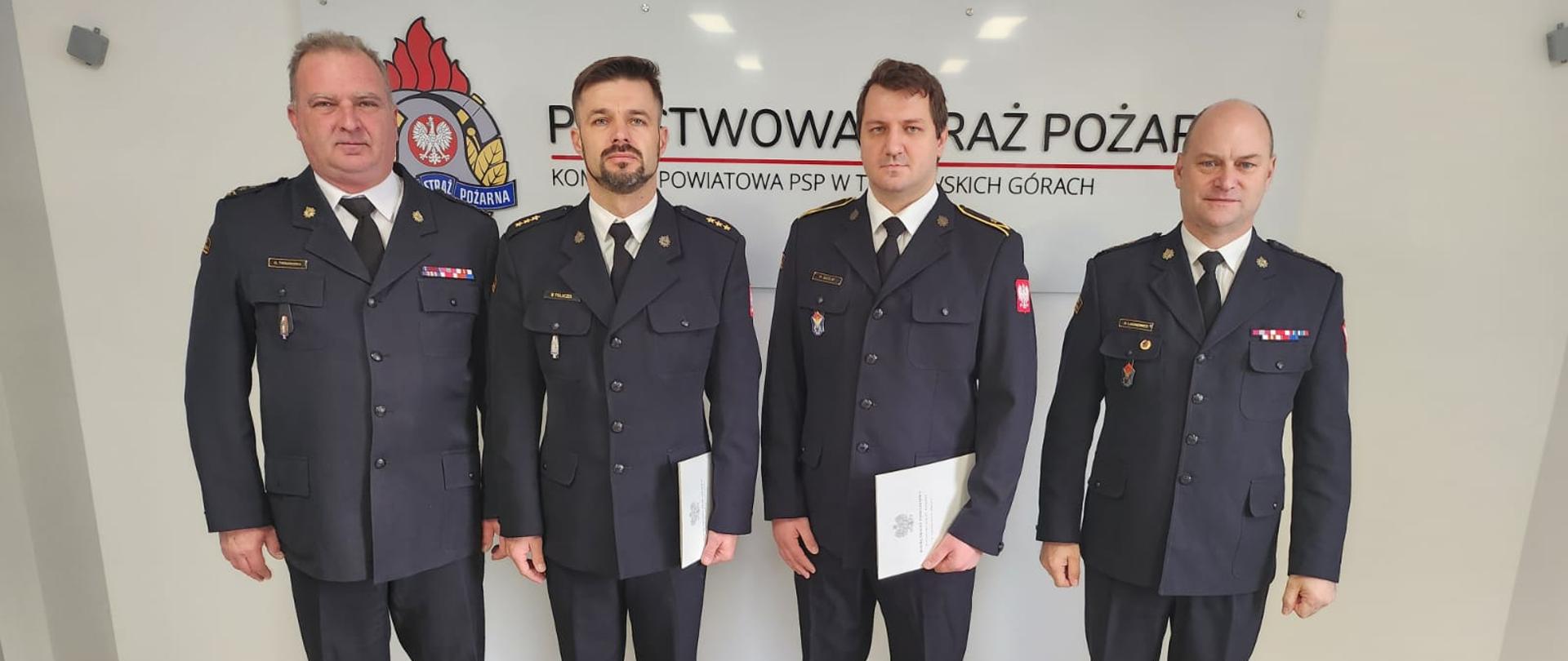 Strażacy w mundurach wyjściowych pozują do zdjęć.