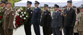 Delegacja przedstawicieli służb mundurowych stojąca na Placu Pamięci Narodowej podczas uroczystości przed złożeniem wieńców przed Pomnikiem Poległym w Obronie Ojczyzny 1939-1945