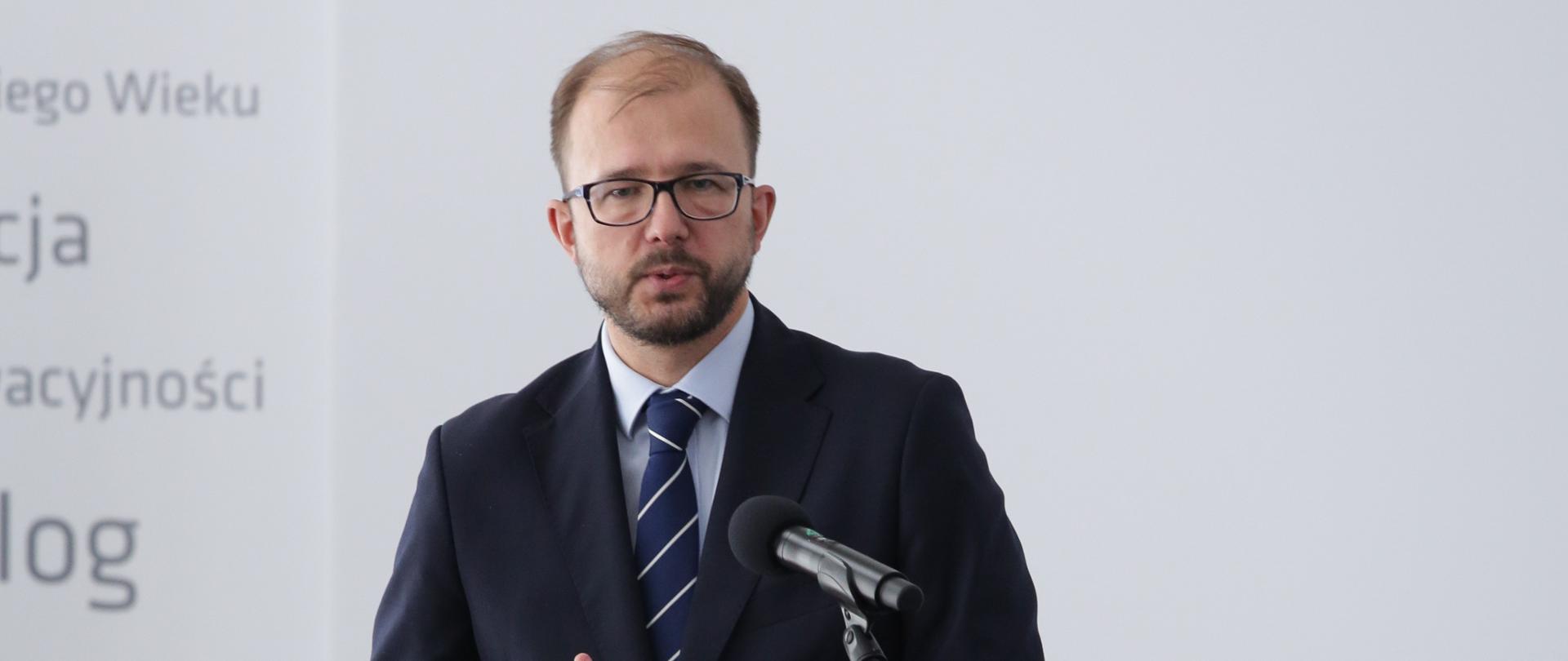 Na zdjęciu widać wiceministra Piotra Dardzińskiego, przemawiającego na scenie.