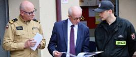 Wizyta Wiceministra Spraw Wewnętrznych i Administracji oraz kadry PSP u druhów ochotników - wiceminister i nadbryg. Paweł Frysztak przeglądają kronikę, obok druh ochotnik
