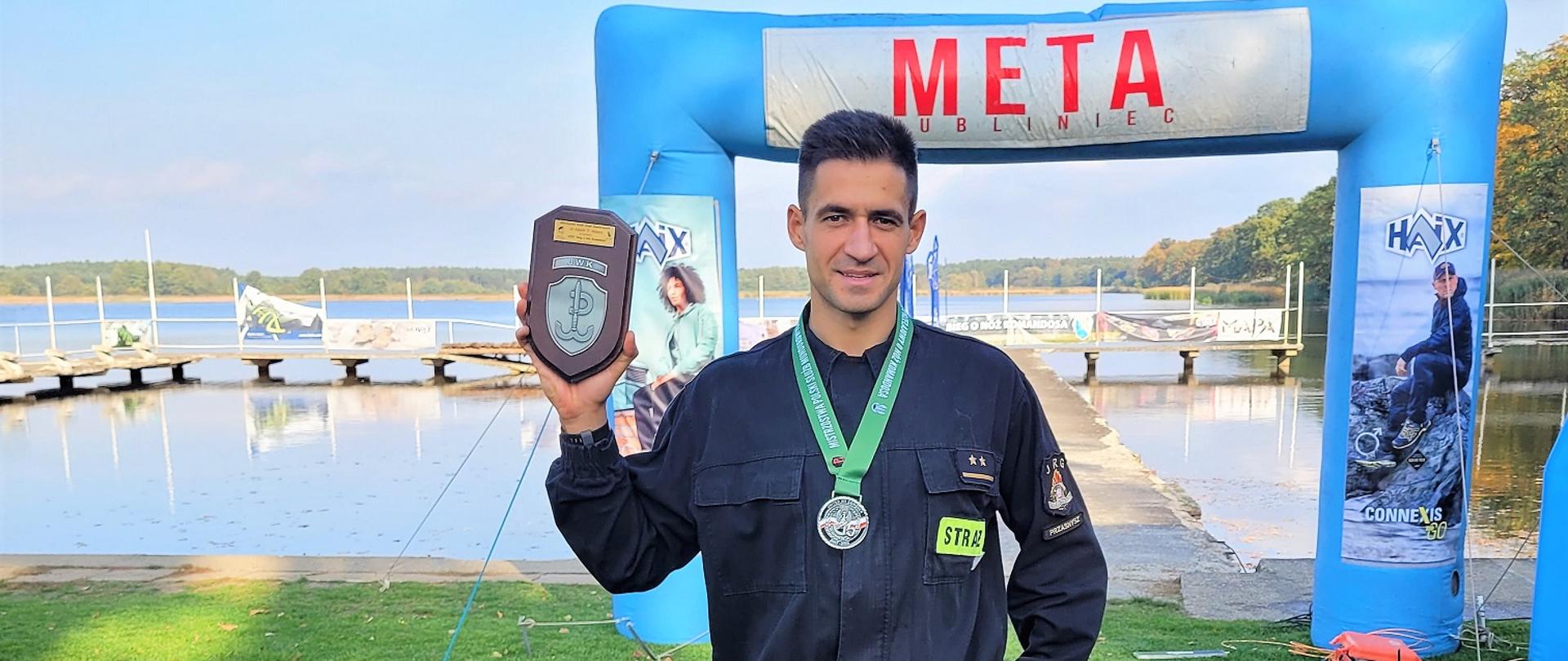 8 października 2022 r. w XXVI Biegu Przełajowym o Nóż Komandosa im. gen dyw. Włodzimierza Potasińskiego i zarazem Mistrzostwach Polski Służb Mundurowych w Crossie udział wzięło ok. 555 zawodników, którzy pokonywali 15 kilometrową trasę w lesie, na trudnym i górzystym terenie pod Lublińcem w umundurowaniu.
W zawodach brali udział m. in. przedstawiciele wojska, policji, straży pożarnej oraz cywile.
Komendę Wojewódzką PSP w Warszawie reprezentowała drużyna w składzie 25 zawodników.
Młodszy kapitan Rafał Smoliński z czasem 1 godziny, 10 minut i 18 sekund wywalczył wicemistrzostwo Polski Mistrzostw Służb Mundurowych w Crossie w kategorii „Straż Pożarna”.
Naszemu reprezentantowi gratulujemy i życzymy kolejnych sukcesów!
Opracowanie: asp. Rafał Sekuna na podstawie informacji mł. kpt. Rafała Smolińskiego.
Zdjęcia: zmierzymyCzas.pl.
