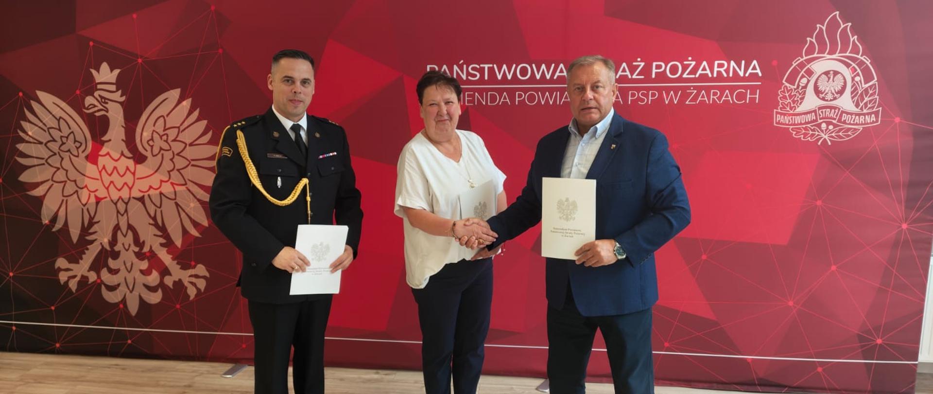 Oficjele po podisaniu porozumienia stoją na tle PSP