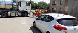Na pierwszym planie nieoznakowany radiowóz śląskiej ITD. W tle ciężarówka stojąca w miejscu śmiertelnego potrącenia pieszej. Obok ciężarówki stoją strażacy.